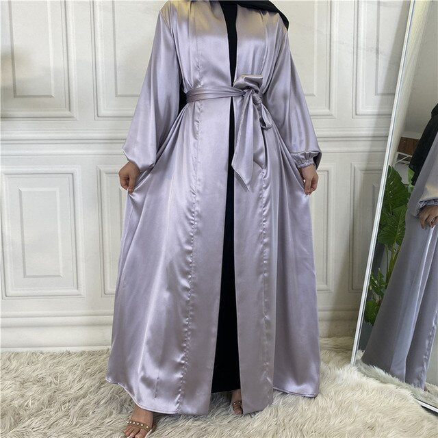 Person wearing a light purple satin robe standing in front of a mirror.