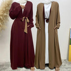 Two long dresses, one maroon and one brown, on a neutral background.