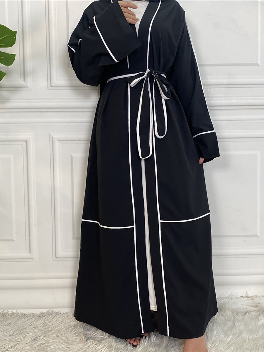 Black abaya with white trim on a white background