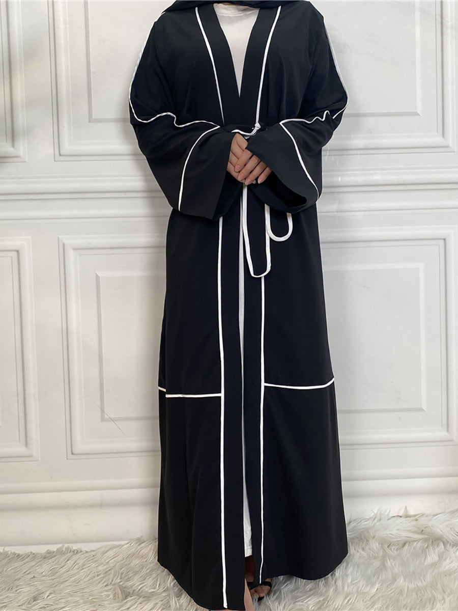 Black abaya with white piping on a white background